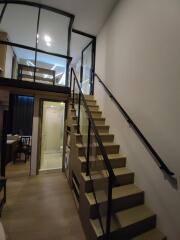 Interior of a modern loft with a staircase leading to a mezzanine level