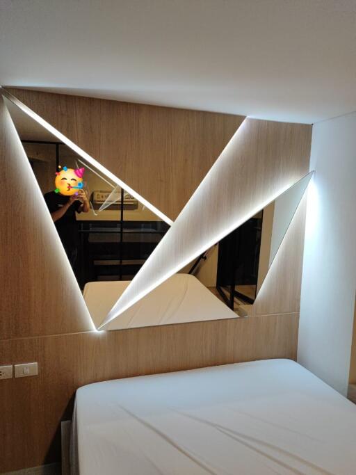 Modern bedroom with unique geometric mirror and ambient lighting