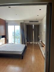 Bedroom with large window and urban view