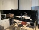 Modern kitchen with black and white cabinetry and island