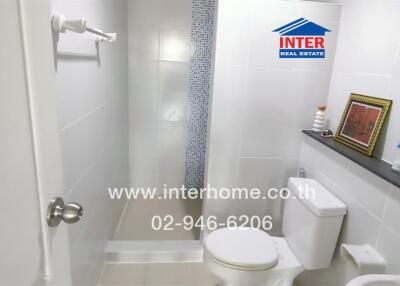 Bathroom with toilet, shower, and decorative items