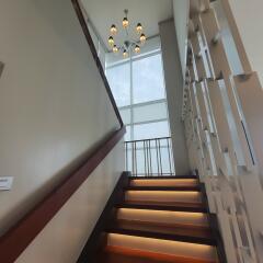 Modern staircase with illuminated steps and large window