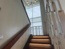 Modern staircase with illuminated steps and large window