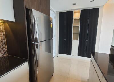 Modern kitchen with stainless steel refrigerator, black and white cabinets, and tiled backsplash