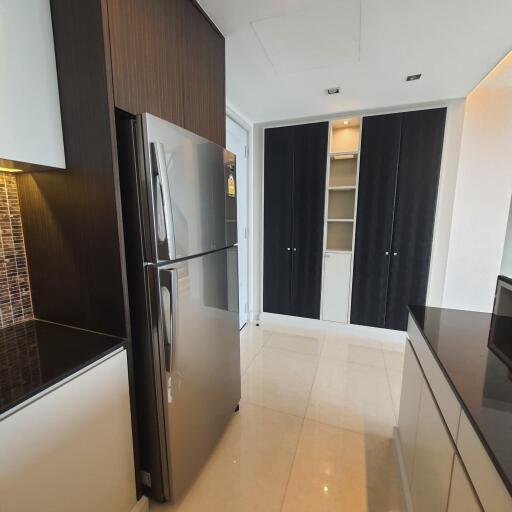 Modern kitchen with stainless steel refrigerator, black and white cabinets, and tiled backsplash