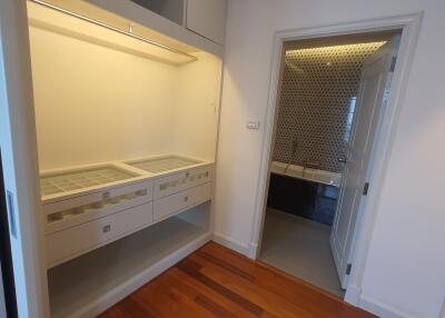 Walk-in closet with built-in storage drawers and open shelves