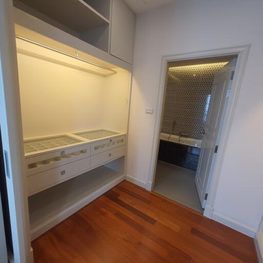 Walk-in closet with built-in storage drawers and open shelves