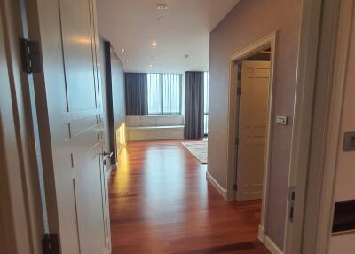 Living area with wooden flooring, large windows, and adjoining rooms