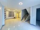 Spacious living room with stairs and modern lighting