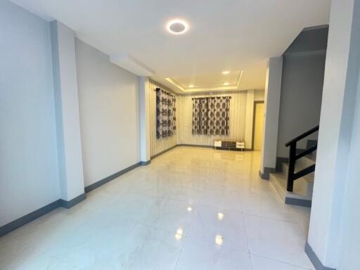 Spacious living room with tiled floor and decorative curtains