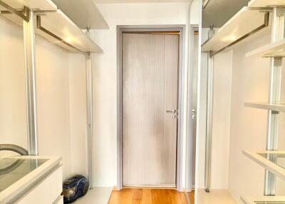 Walk-in closet with wooden floor and storage racks