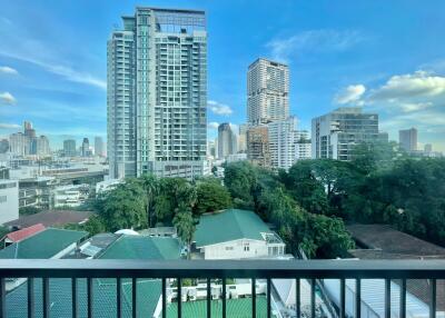 View of cityscape from a high-rise building with a balcony railing in the foreground