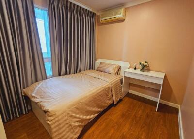 Well-lit bedroom with single bed and desk