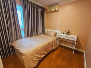 Well-lit bedroom with single bed and desk