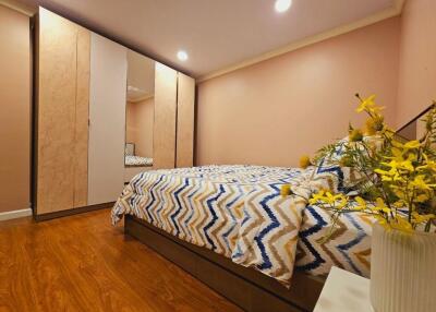 Modern bedroom with patterned bedding and large wardrobe