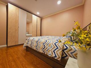 Modern bedroom with patterned bedding and large wardrobe