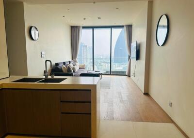 Living area with sofa, wall-mounted TV, and city view from large windows