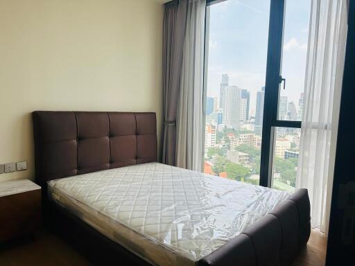 Bedroom with large window and city view