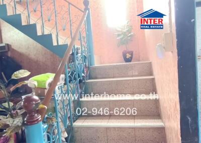 Staircase leading to upper floor with blue railing and tiled steps