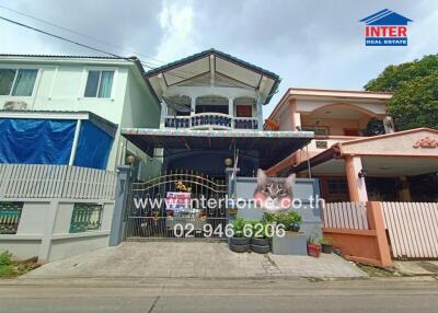 Exterior view of a two-story house with a front gate