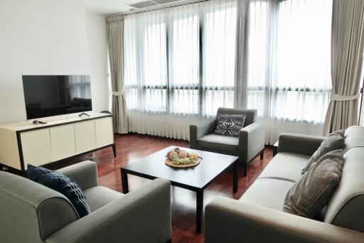 Modern living room with a large window, sofas, TV and a coffee table