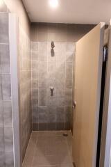 Shower area with tiled walls and a door