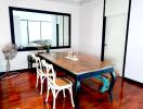 Stylish dining room with wooden table, chairs and a large mirror