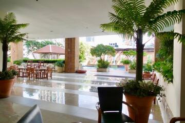 Outdoor lounge area with tables, chairs, and potted plants