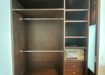 Wooden built-in wardrobe with open shelves and drawers