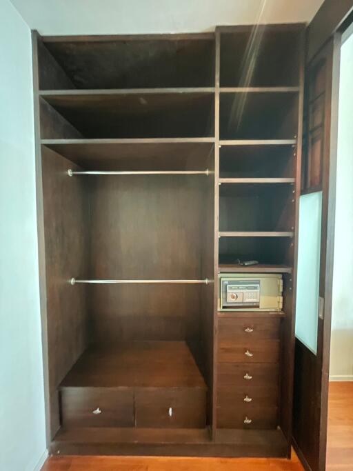 Wooden built-in wardrobe with open shelves and drawers