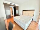 Spacious and bright bedroom with wooden flooring and built-in wardrobe