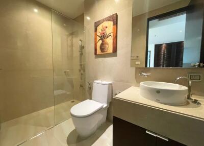 Modern bathroom with glass shower, toilet, and vanity