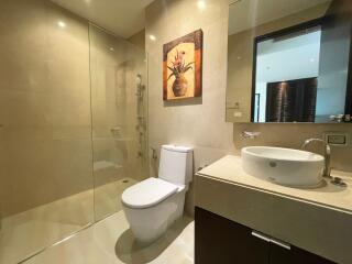 Modern bathroom with glass shower, toilet, and vanity