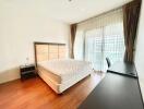 Well-lit bedroom with a large bed and study desk