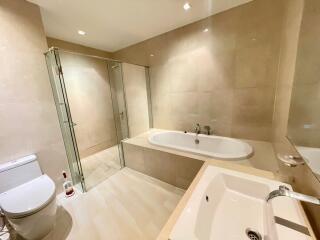 Modern bathroom with bathtub, shower, toilet, and sink