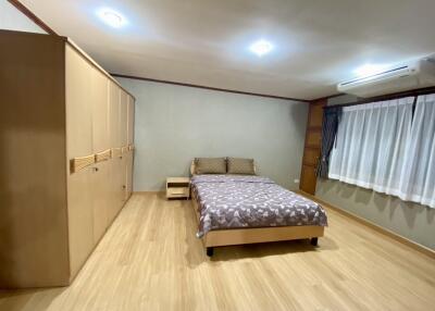 Spacious bedroom with wooden flooring and ample storage