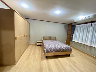 Spacious bedroom with wooden flooring and ample storage