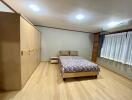 Spacious bedroom with wooden flooring and ample storage