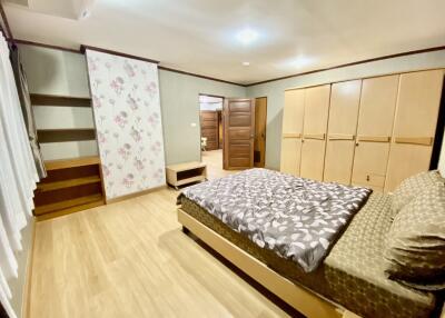 Spacious bedroom with large bed, wooden furniture, and built-in closet