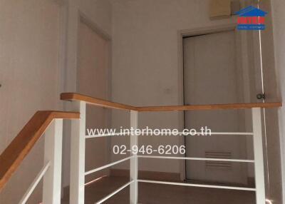 Hallway with white walls and wooden handrail