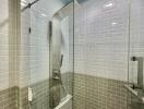 Modern bathroom with glass shower enclosure and subway tile walls