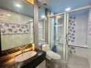 Modern bathroom with floral tiles and glass-enclosed shower