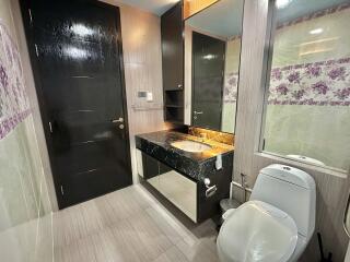 Modern bathroom with large mirror and black marble countertop