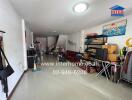 Spacious living room with tiled floor and various furniture items, including a sofa, shelves, and exercise equipment.