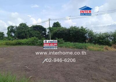 View of a vacant land plot with a real estate sign