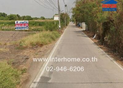 Narrow road with a real estate sign