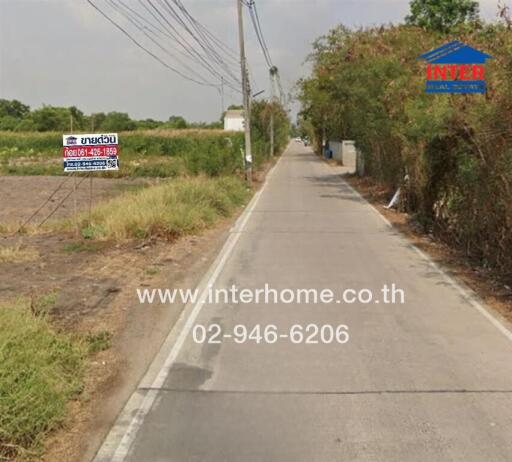 Narrow road with a real estate sign