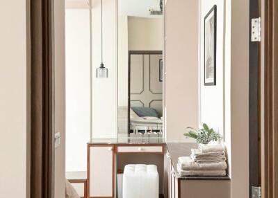 Modern bedroom view through open door with wooden flooring, stylish decor, and natural light