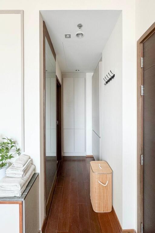 Clean and modern hallway with wooden flooring and a storage basket