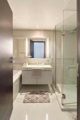 Modern bathroom with vanity, bathtub, and glass shower enclosure